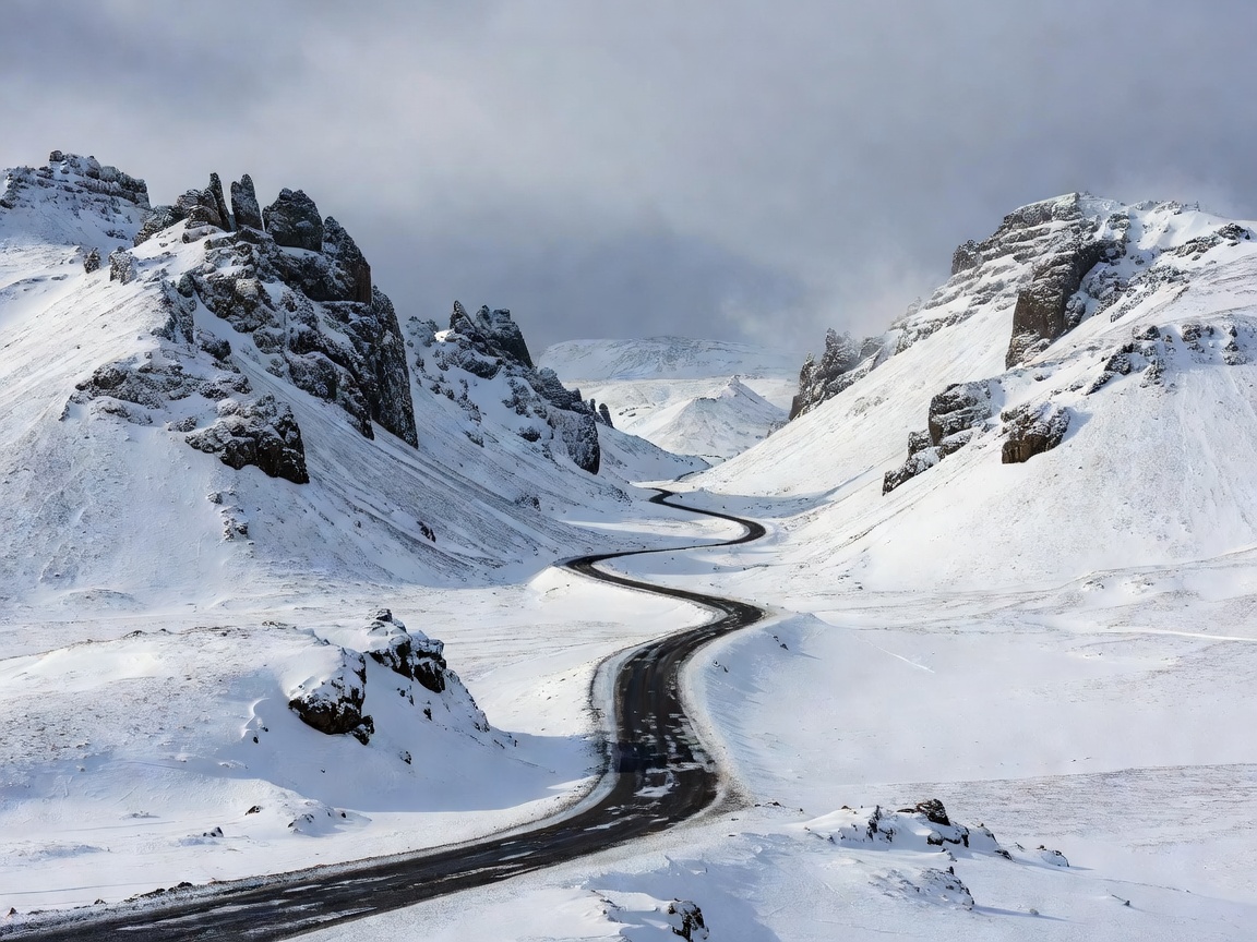A winding winter road between Icelandic volcanic ridges